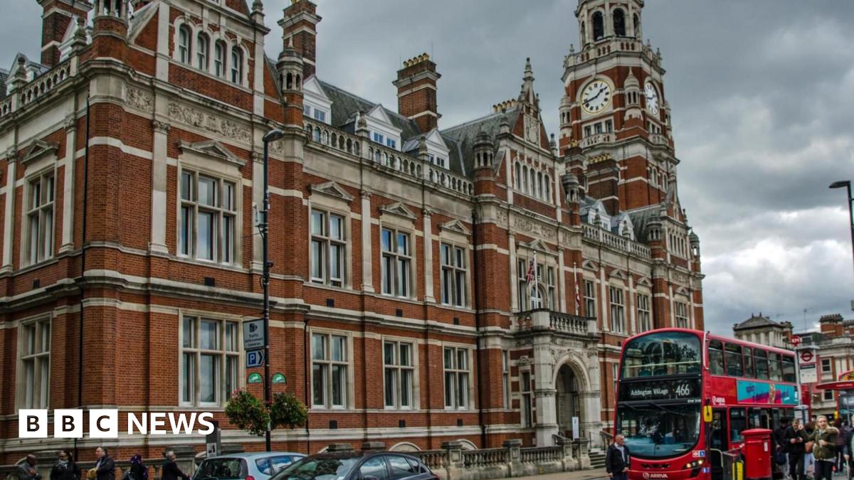 Croydon town hall, a red brick building with flags outside and a red bus at a stop.