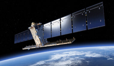 illustration of a boxy satellite with large solar arrays above earth