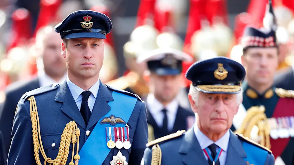 Prince William marching behind his father KIng Charles in uniforms.