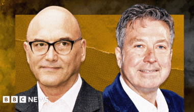 Designed image showing headshots of Gregg Wallace and John Torode. Wallace is on the left, he has a shaved head, black rimmed glasses and is wearing a white open-necked shirt with grey jacket. Torode has short greying hair, a white open-necked shirt and grey jacket.