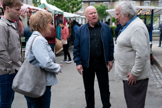 Julie approaches a confused Nigel as Phil and Jay watch on in EastEnders