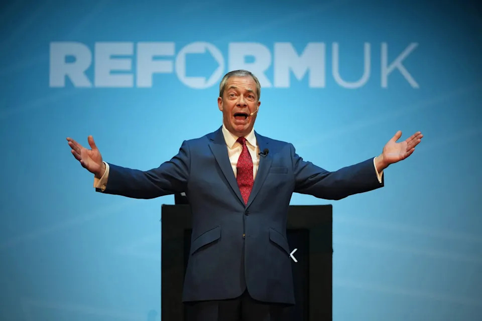 Nigel Farage speaking in front of Reform UK sign