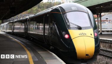 A dark green Great Western Railway train pulls up to an empty train platform at Bristol Temple Meads.