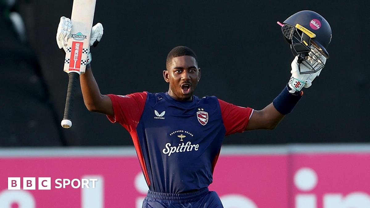 Tawanda Muyeye raises his helmet and bat in each arm in celebration