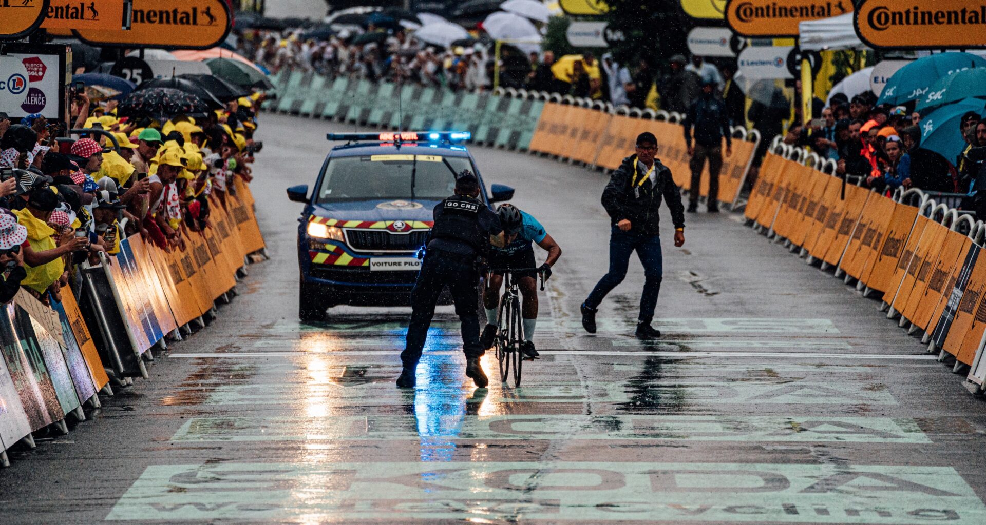 A protestor is tackled at the finish of stage 17 of the Tour de France