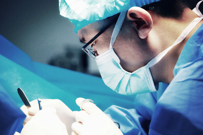 Surgeon wearing mask and cap performing surgery, highlighting terrifying and horrible mistakes made in hospitals.