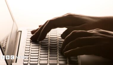 Close up of hands typing on a laptop.
