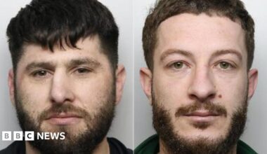 Two side by side police mugshots. Both have beards and moustaches, brown hair, and neutral expressions. Gjonaj, left, is squinting slightly and has brown eyes. His hair is slightly darker. Zefi has a neutral expression and green eyes.