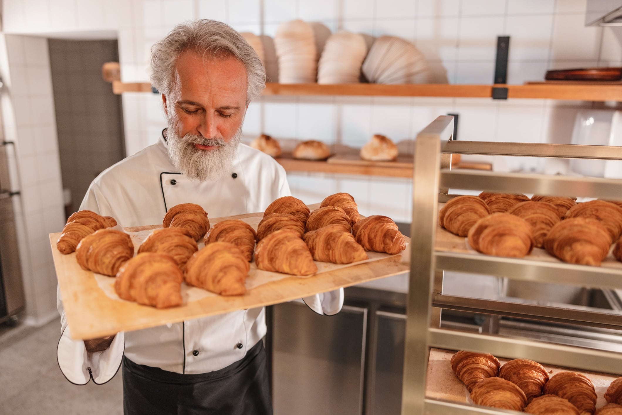 Baker holding freshly baked croissants