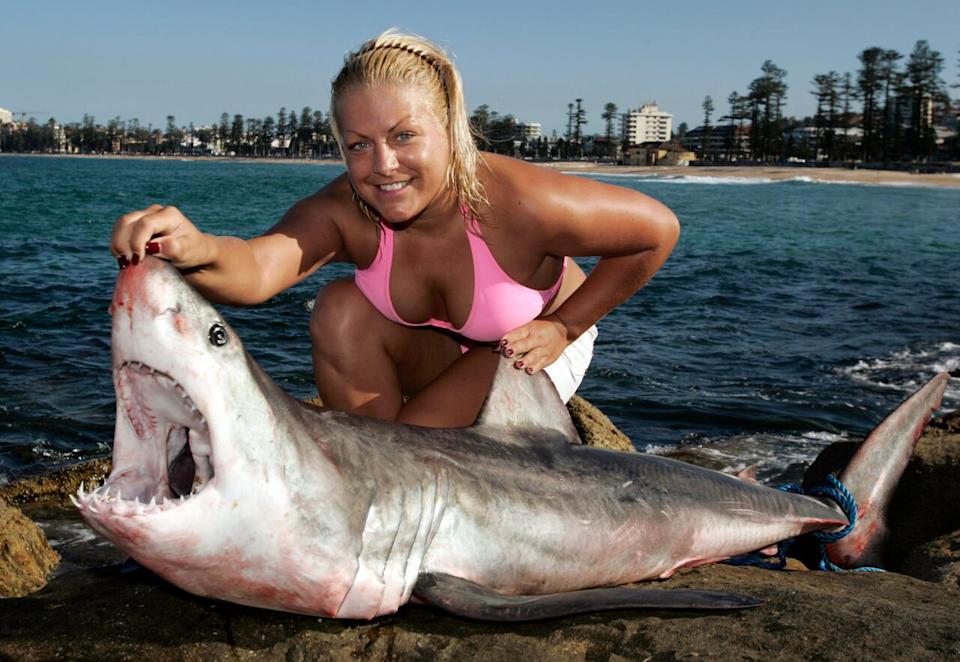 Joanne Nichols of Liverpool in England poses with a dead Mako shark which was washed onto rocks at Queenscliff beach in Sydney April 1, 2008. The Mako shark, a pelagic fish, inhabits the oceans of the world and is normally found in open oceans making this find unusual.