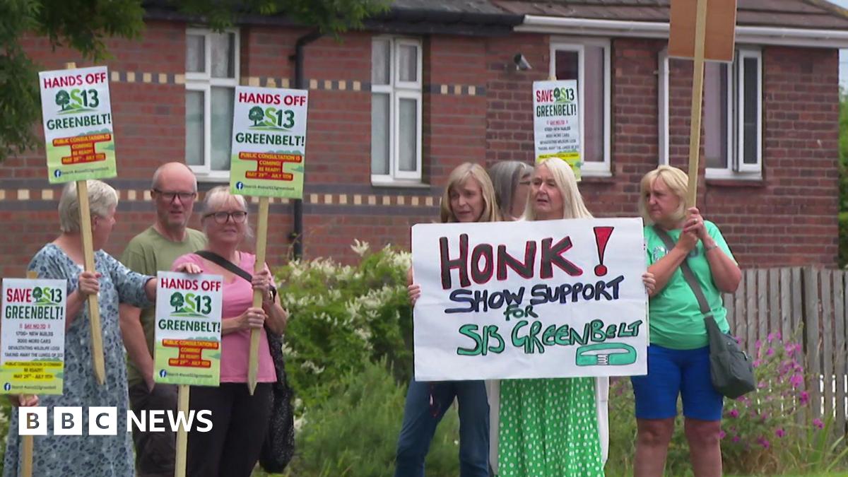 Five women and one man hold placards on the side of the road. One of the signs reads: Honk! Show support for S13 Greenbelt