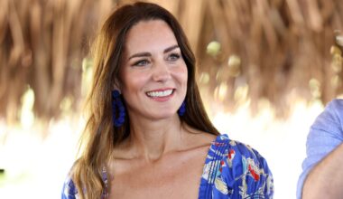 Catherine, Princess of Wales smiles during a visit to Hopkins in Belize, wearing blue statement earrings and a patterned dress