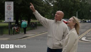 Irvine Welsh and Katie Razzall in Leith. He is pointing up at a building.
