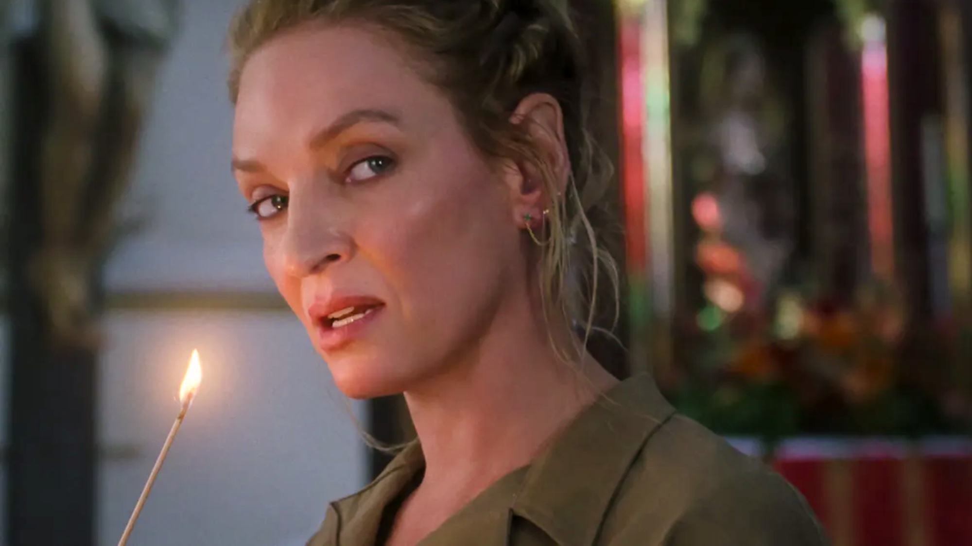 Discord (Uma Thurman) holding a lit matchstick in a scene from 