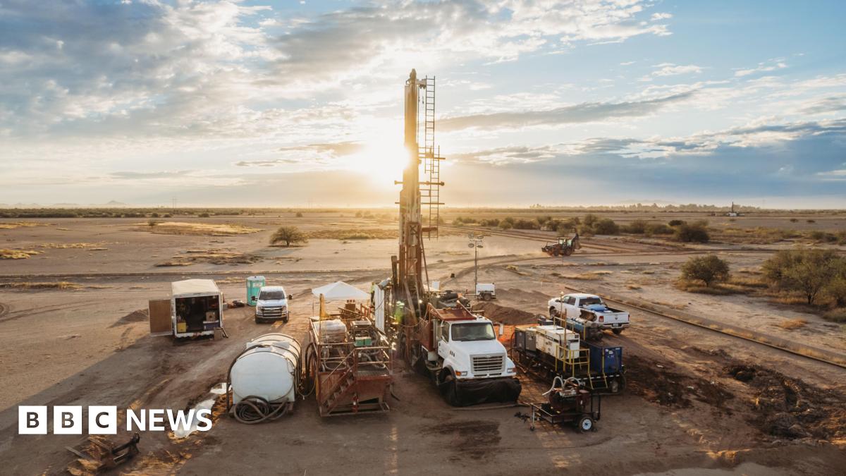 Image of machinery and work trucks on a brown field - the site of Ivanhoe Mining Ltd's Santa Cruz project in Arizona - with the sun setting behind the machinery