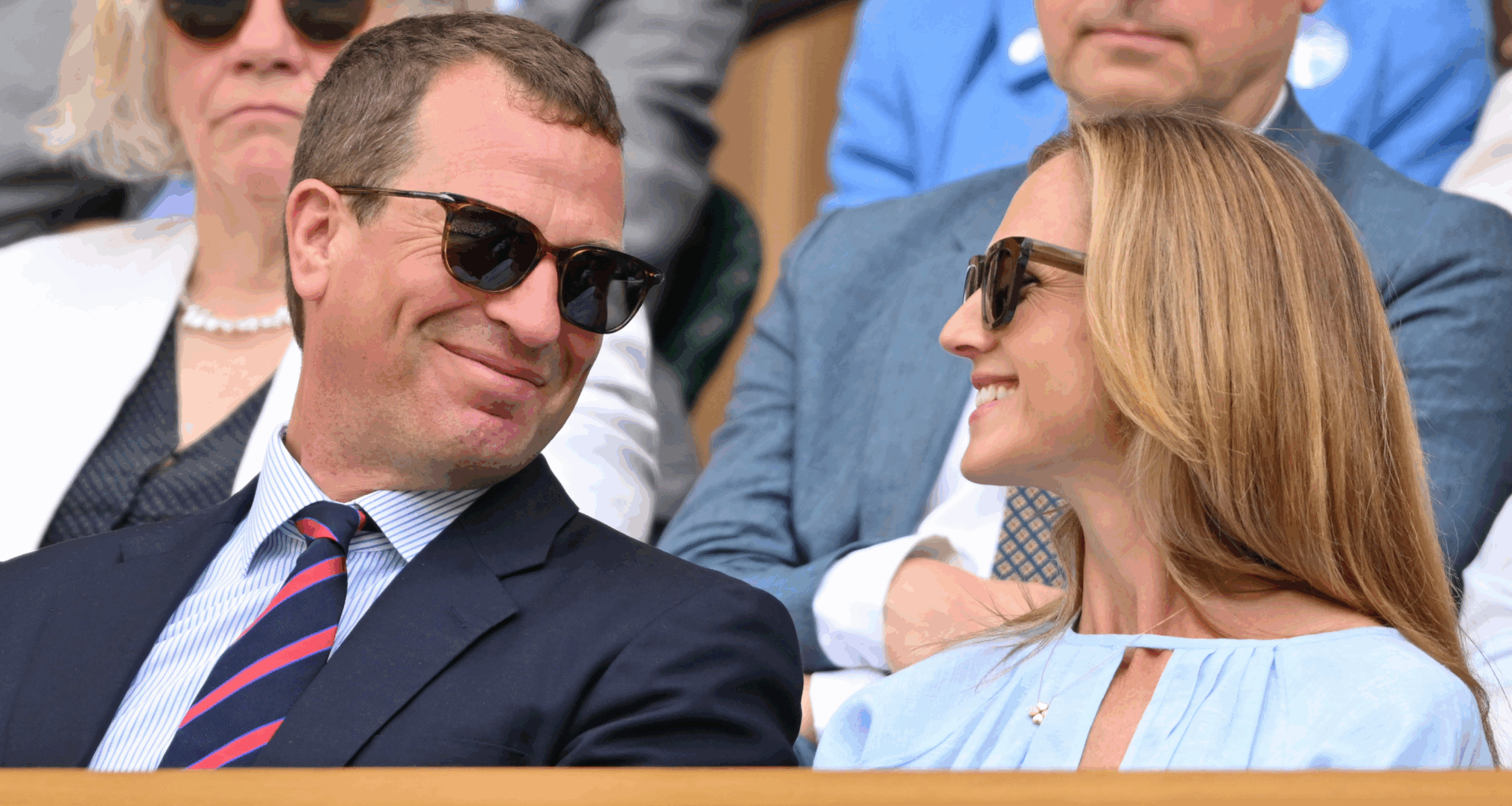 Peter Phillips and Harriet Sperling smiling at each other at Wimbledon wearing sunglasses