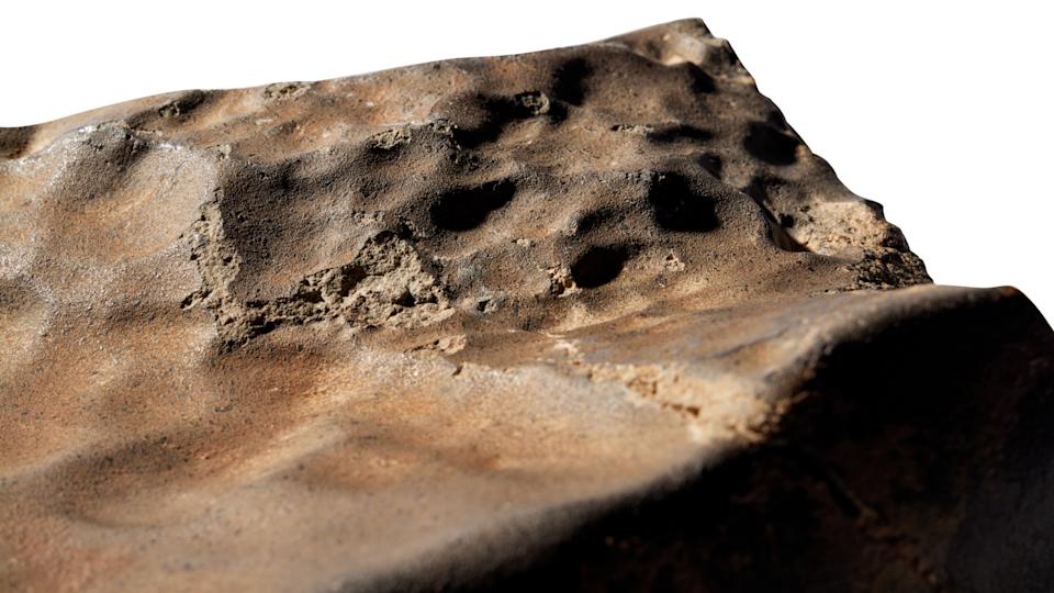 Closeup of a Mars meteorite. Reddish-brown, rocky surface.