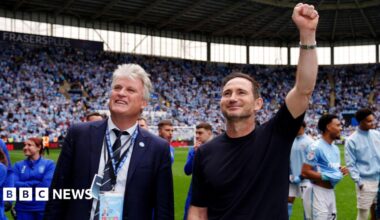 Coventry City owner Doug King pictured with manager Frank Lampard at the Coventry Building Society Arena celebrating with fans. They are both smiling and Frank Lampard has his left first raised in celebration.