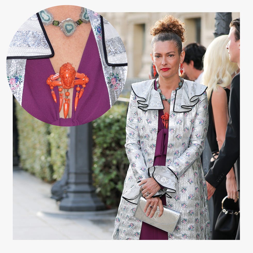 Fashion-forward outfit featuring an ornate coat and unique accessories.