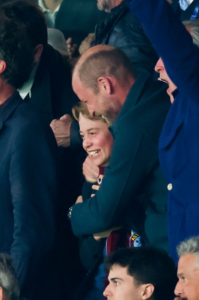 Prince William hugging George at football match