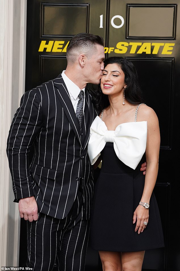 John Cena shared a smooch with his glamorous wife Shay Shariatzadeh as they attended a special screening of his new film Heads of State in London on Tuesday