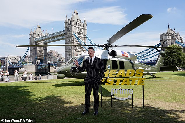 John held up a peace sign as he posed in front of Tower Bridge