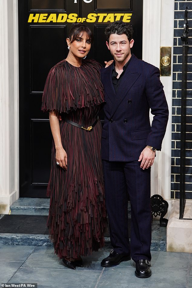 The star styled her dark locks in a neat up do as she beamed for photos alongside husband Nick Jonas