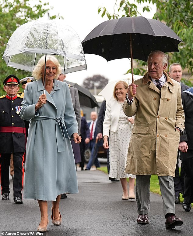 The monarch looked dapper in a smart, brown overcoat, grey suit trousers, and a pair brown brogues