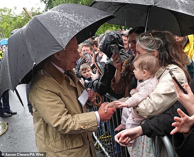 Before greeting the young child, the 76-year-old royal chatted with her mother and shook her hand