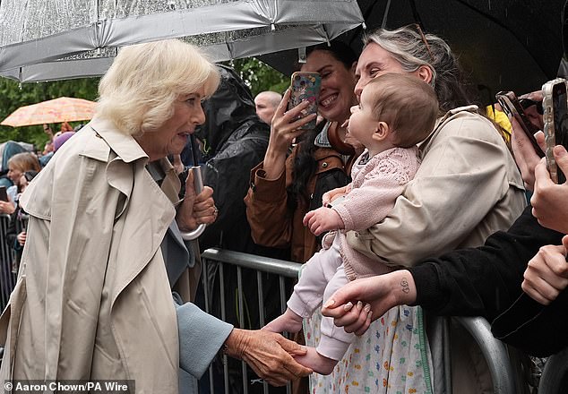 A mother held her young daughter out to Queen Camilla, who appeared delighted to greet the child