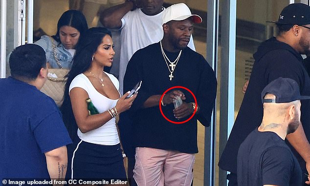 The boxing icon was seen holding a wad of cash as they made their way out of a designer store