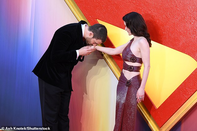 Her co-star David - who takes on the role of Superman - sweetly kissed her hand as they posed on the red carpet