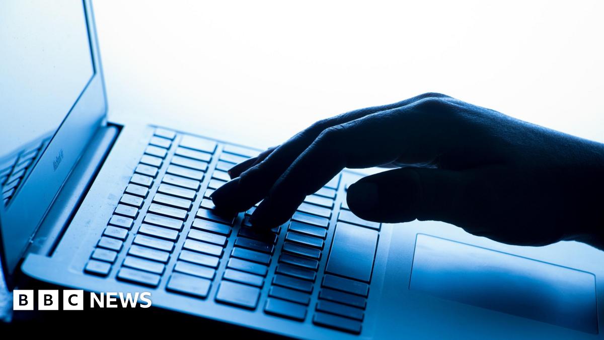 A hand on a keyboard in a blue shade of light.