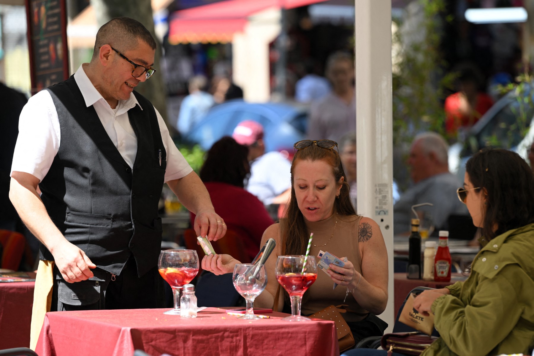 A customer pays a waiter in Spain