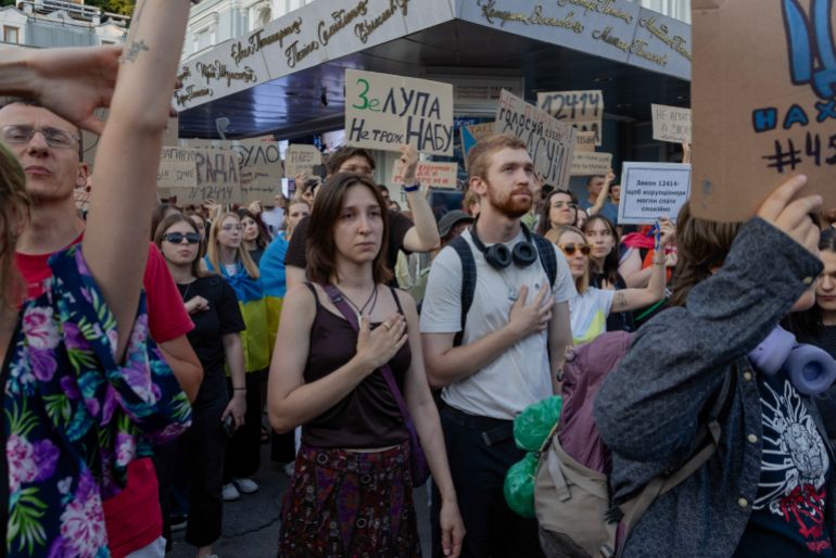 Protesters hold placards during a demonstration against a law that removes the independence of the NABU and SAPO anti-corruption agencies, in Kyiv on July 24, 2025, amid the Russian invasion of Ukraine Ukraine's anti-corruption body NABU said a new bill submitted to parliament on July 24 would restore its independence, after President Volodymyr Zelensky backtracked under pressure from nationwide protests and the EU. (Photo by Tetiana DZHAFAROVA / AFP)