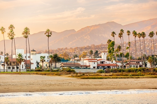 Santa Barbara beach with palm trees and city skyline at sunset, California, USA
