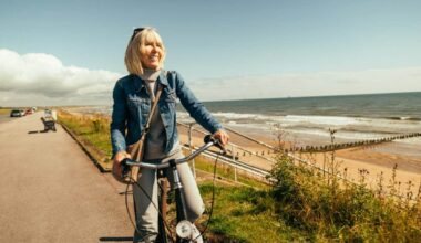 Woman riding her old fashioned bicycle along the Beach Esplanade at Aberdeen, Scotland.