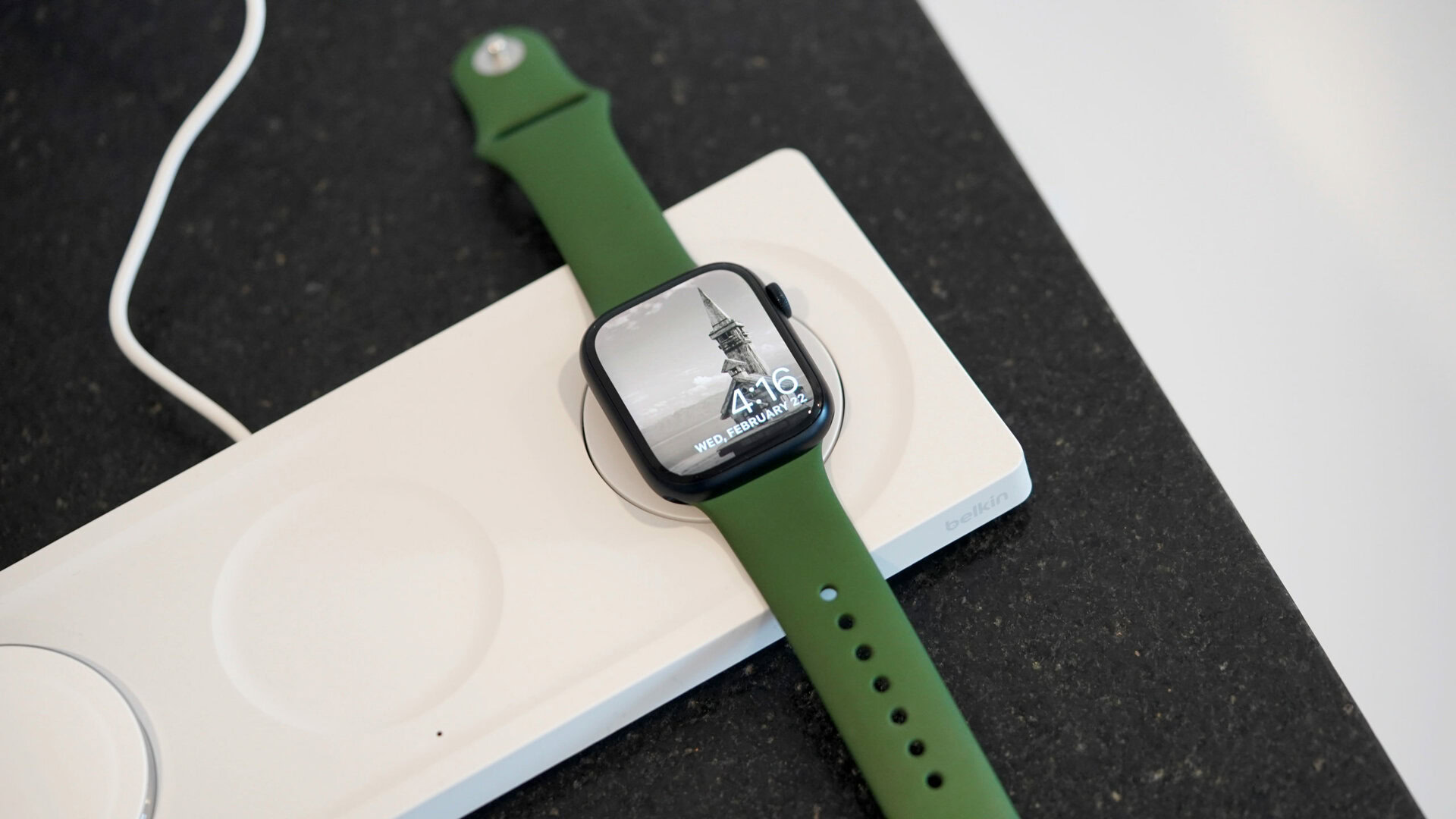 An Apple Watch charges laying flat on Belkin BoostCharge Pro 3 in 1 Wireless Charger.