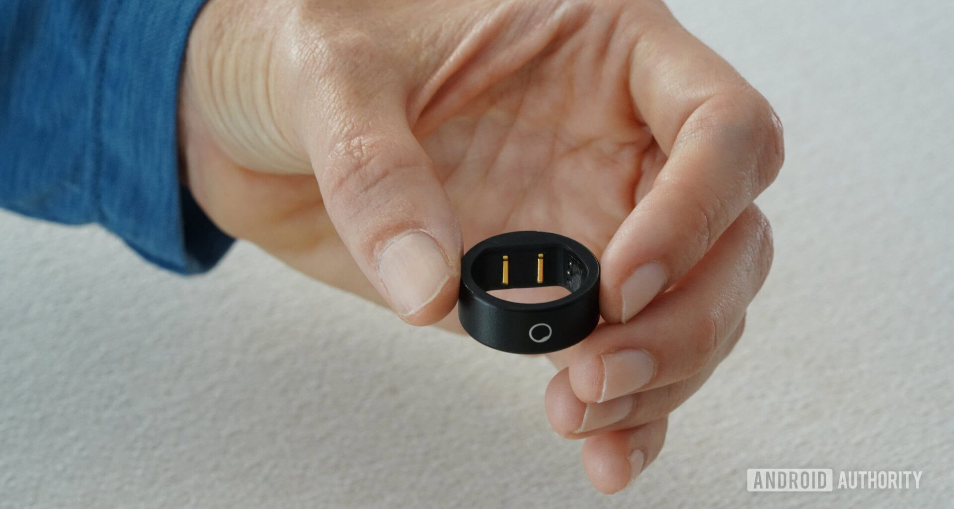 A users holds a Circular Ring Slim displaying the device's logo.