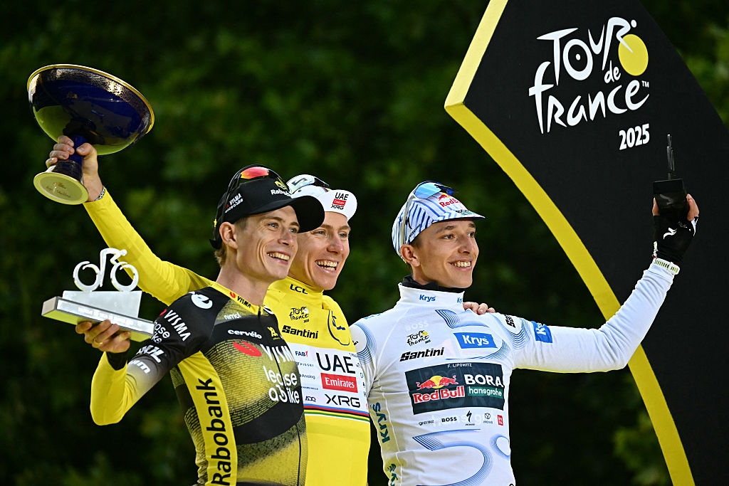 Overall winner UAE Team Emirates - XRG team's Slovenian rider Tadej Pogacar (C) wearing the overall leader's yellow jersey, second-placed Team Visma - Lease a bike team's Danish rider Jonas Vingegaard (L), and third-placed Red Bull - BORA - hansgrohe team's German rider Florian Lipowitz (R) celebrate on the podium after the 21st and final stage of the 112th edition of the Tour de France cycling race, 132.3 km between Mantes-la-Ville and Paris Champs-Ã‰lysees, on July 27, 2025. (Photo by Loic VENANCE / AFP)