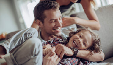 A young couple playing with a child.