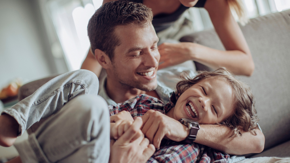 A young couple playing with a child.