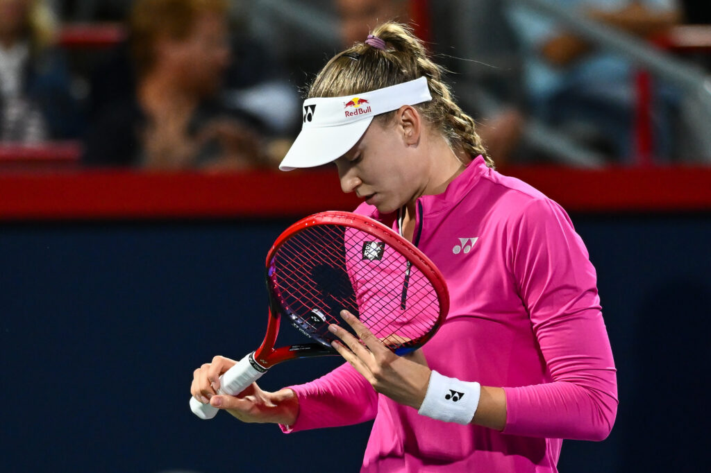 Elena Rybakina looks at her racket