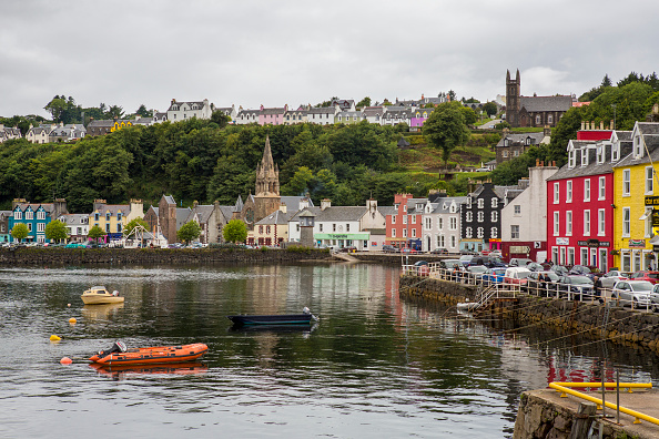 Several small boats float in the harbour of the colourful village of Tobermory, which is located on the Isle of Mull, Scotland. Tobermory, Isle of Mull, Scotland