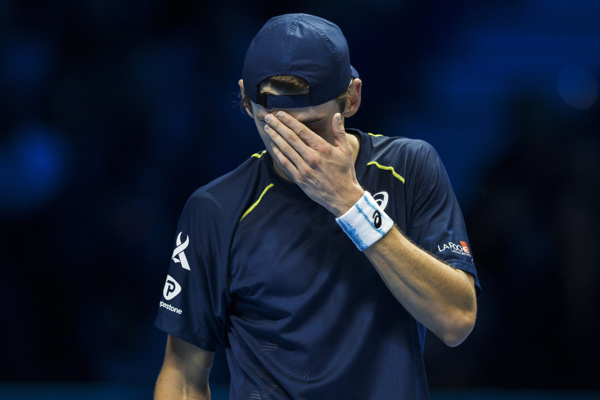 Alex de Minaur covers his face with his hand