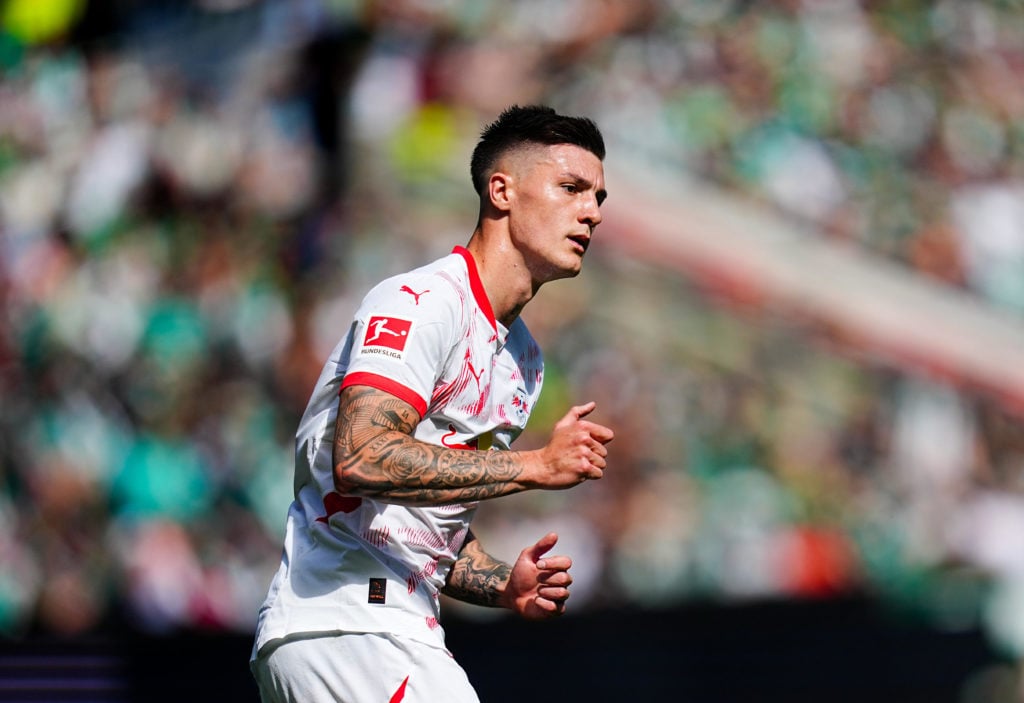 Benjamin Sesko running while wearing RB Leipzig kit.
