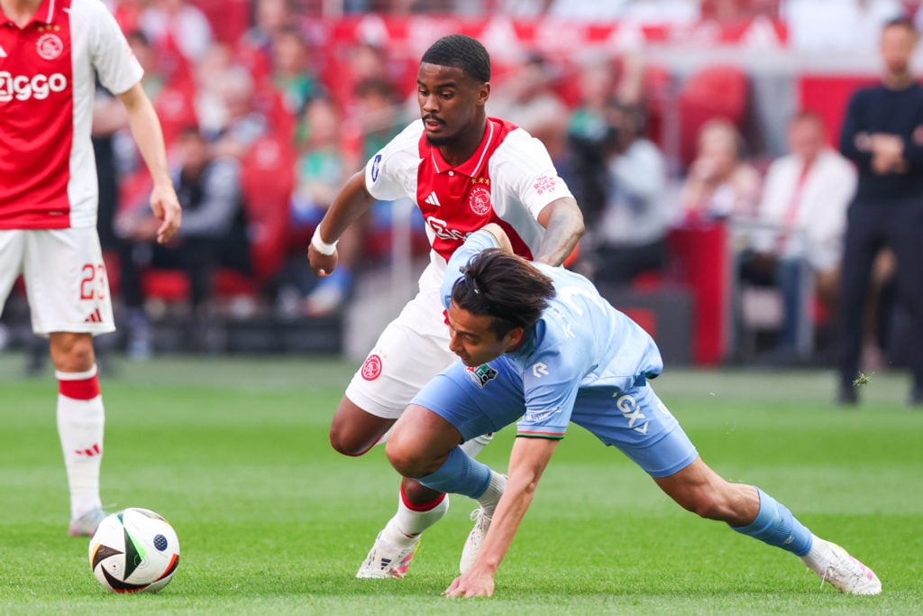 Jorrel Hato defending for Ajax against NEC in an Eredivisie match.
