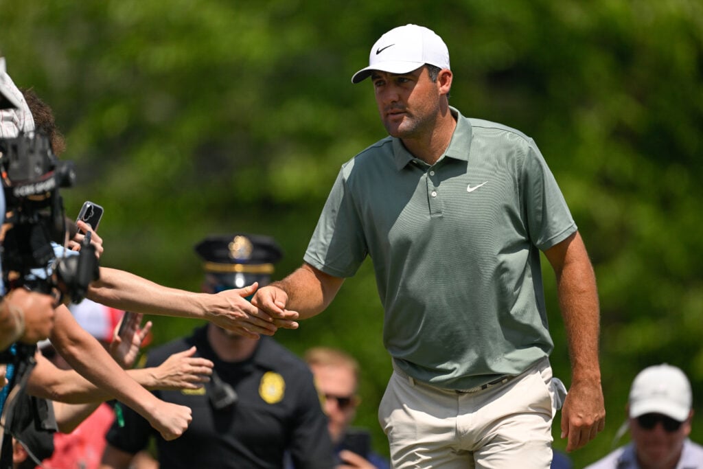 Scottie Scheffler high fives fans during round three of the Travelers Championship