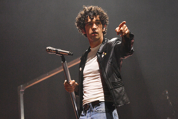 Matty Healy points his finger out while onstage at Glastonbury Festival 2025