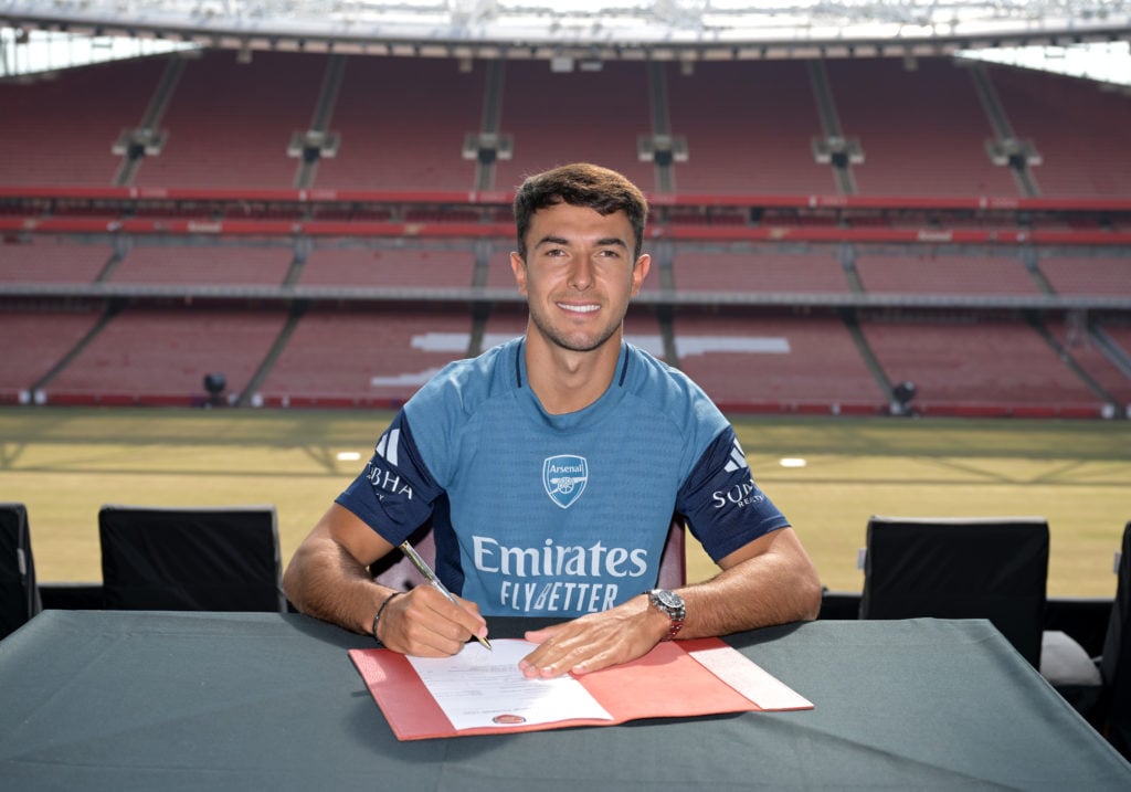 New Arsenal signing Martin Zubimendi poses as he signs a contract in front of the Emirates Stadium